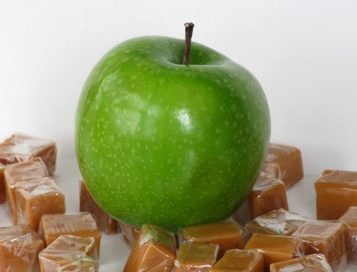 Green apple sitting on top of caramels. 