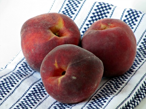 peaches on a blue and white towel.