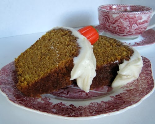 pumpkin loaf cake on a red and white plate with a cup of tea on a saucer.