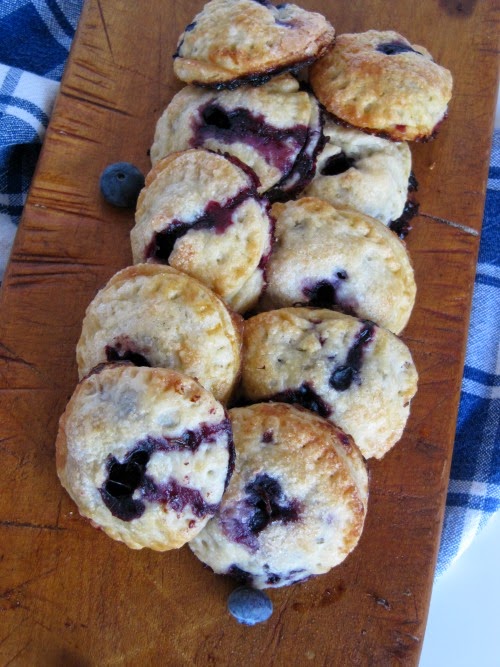 12 blueberry handpies on a cutting board. 