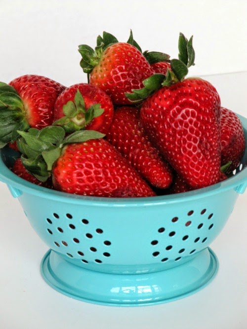 strawberries in a aqua colander. 