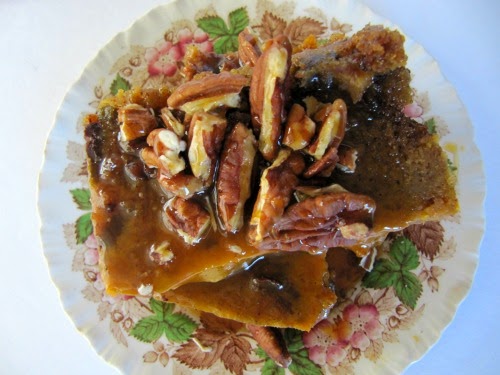 Pumpkin Bread Pudding with Salted Caramel Sauce and Toasted Pecans on a transfer ware plate. 