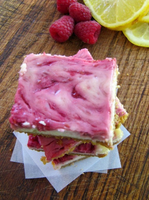 Easy Lemon Raspberry Swirled Cheesecake Bars on a wood cutting board. 
