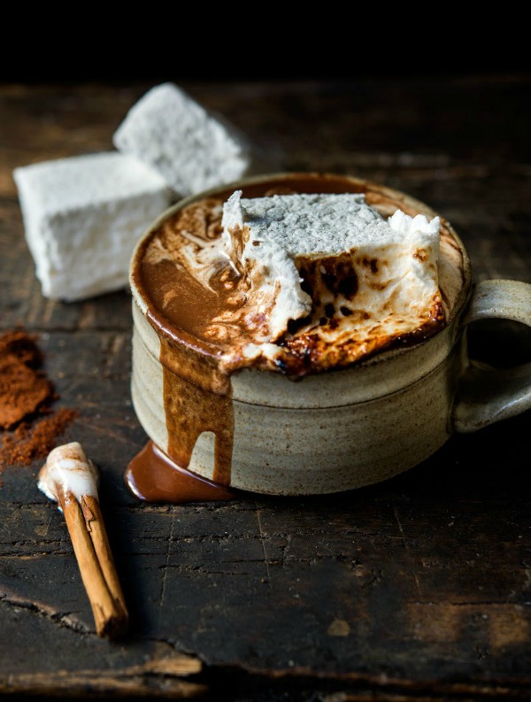 Brown pottery cup of hot chocolate with homemade square marshmallows. 