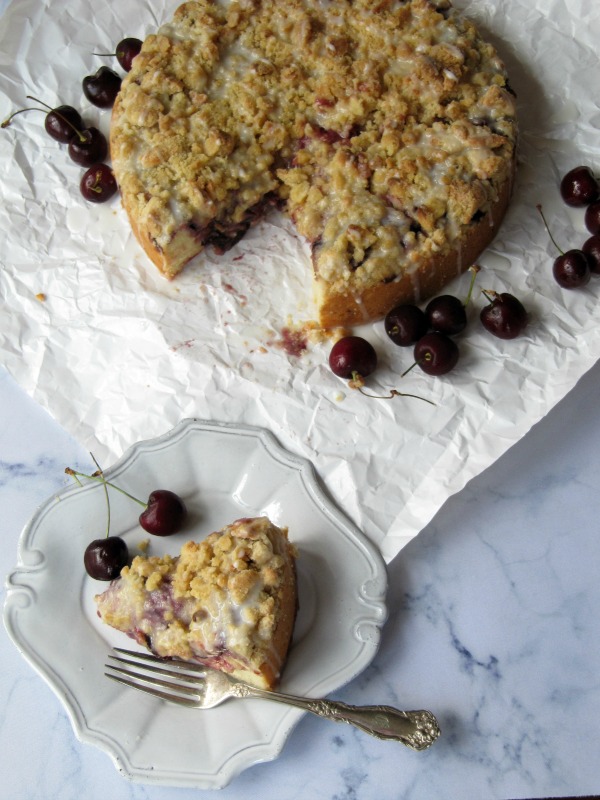 Cherry Almond Coffee Cake sliced on a handmade pottery plate. 