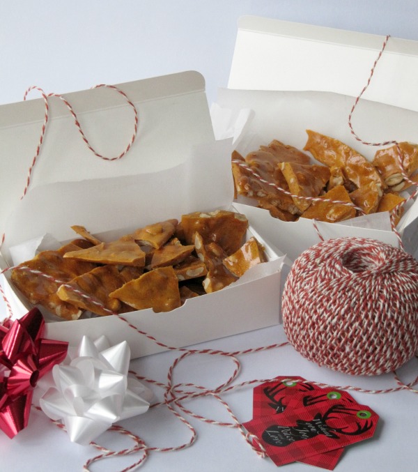 Easy Homemade Peanut Brittle in white boxes with red and white twine.