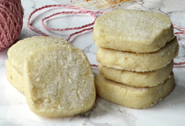 Pile of lemon slice and bake cookies and pink twine. 