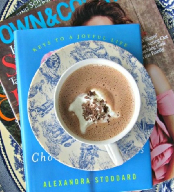 15 Tips for a Healthier Life. Hot chocolate on a stack of books and a magazine. 