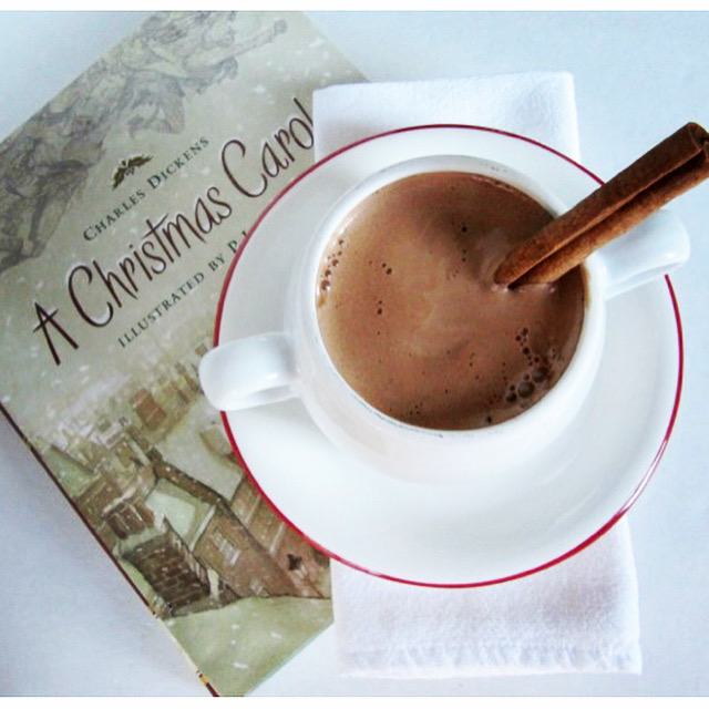 A Christmas Carol with a cup of hot chocolate sitting on top