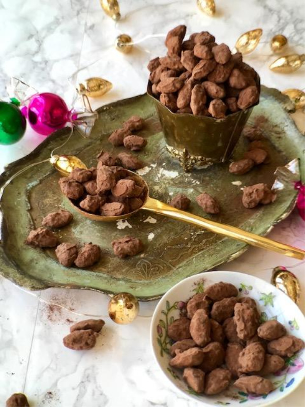 Almond Dragees in a bowl sitting on a vintage pale green Florentine tray. 