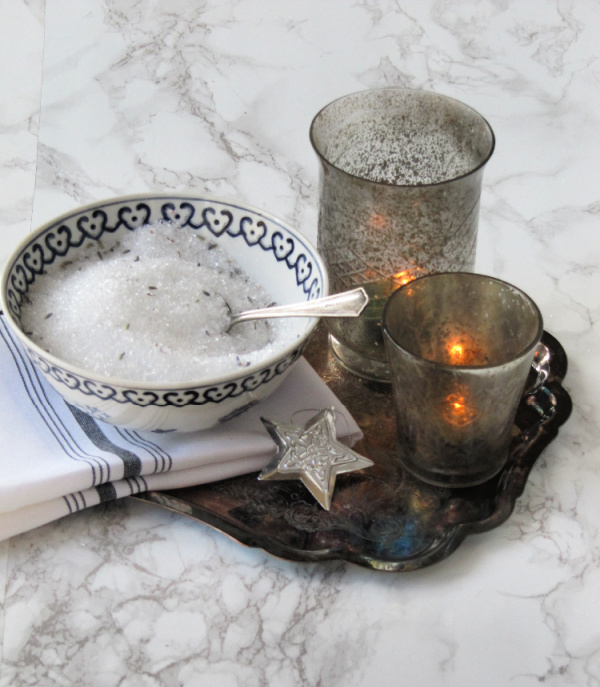 lavender bath salts on a tray with two candles.