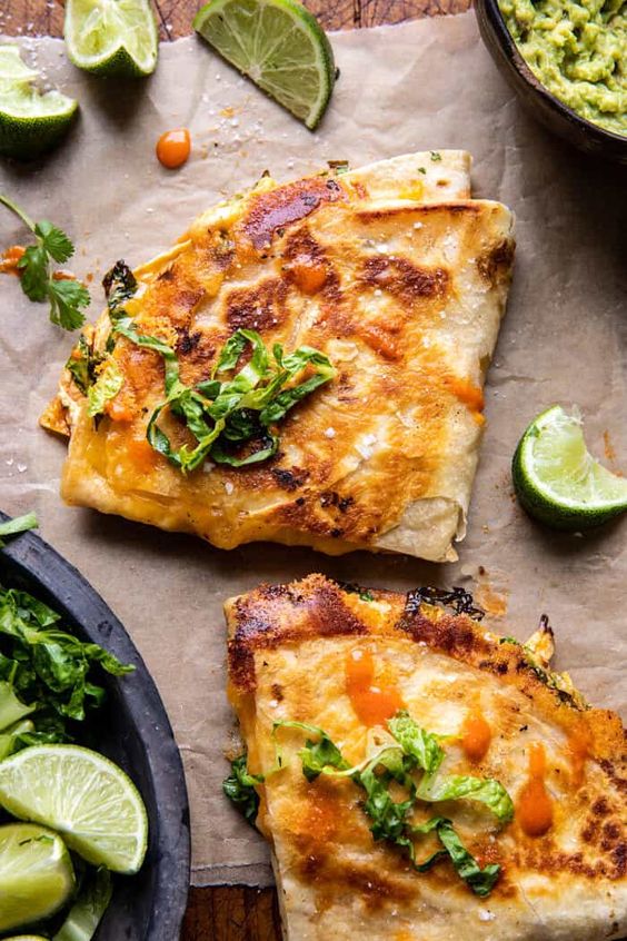 Photo of a folded Buffalo Chicken Wrap with limes scattered around