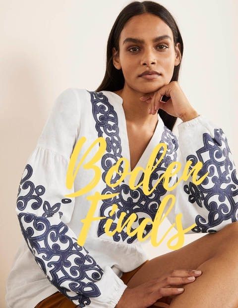 Woman wearing white blouse with blue embroidery