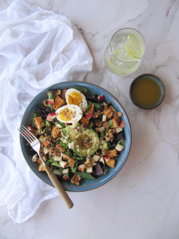 Roasted Sweet potato spinach salad with eggs, avocado and nuts.
