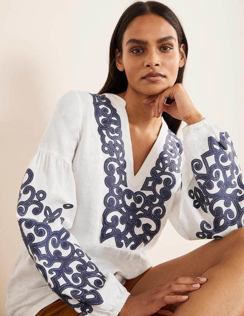 White long sleeved blouse with blue embroidery