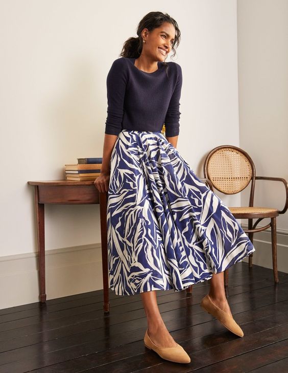woman wearing a blue shirt and a blue and white skirt