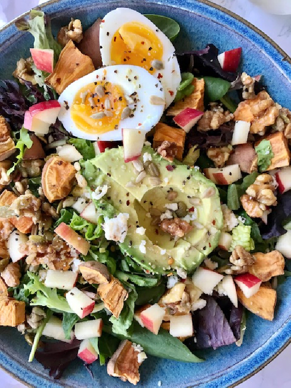 Blue Bowl with spinach egg avocado apple and nut salad