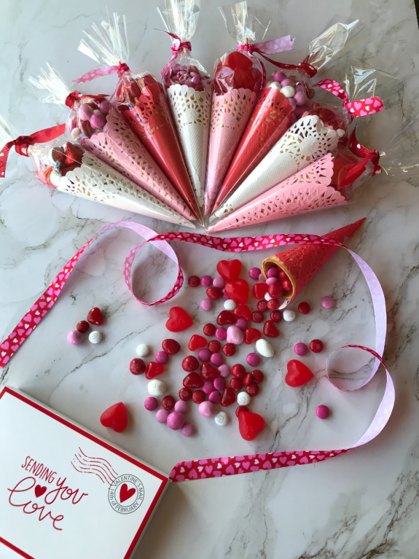 Valentine's Day Candy Favors in pink, red, and white filled with candy.