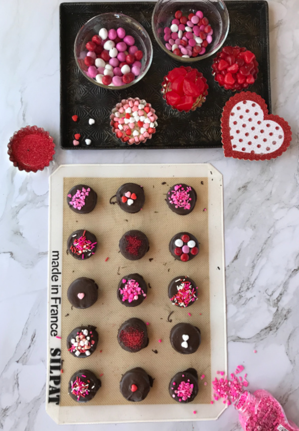 Silphat baking liner with chocolate covered Oreos decorated with colorful sprinkles 