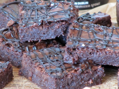 Chocolate brownies stacked and drizzled with chocolate. 