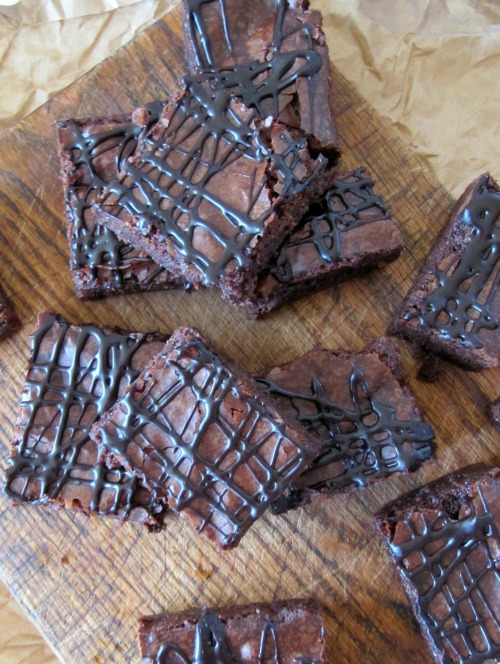 Chocolate Guinness brownies with chocolate drizzle on a cutting board. 
