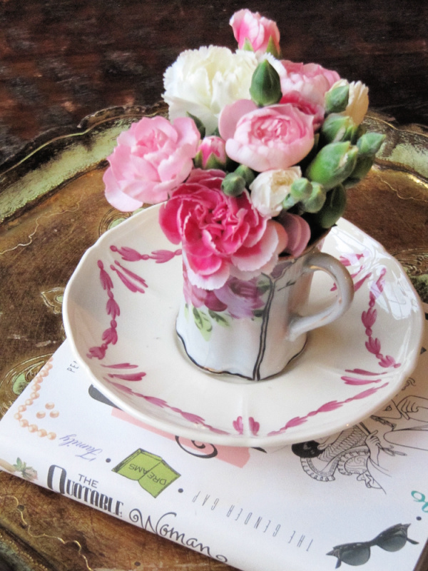 Pink flowers a teacup on a saucer