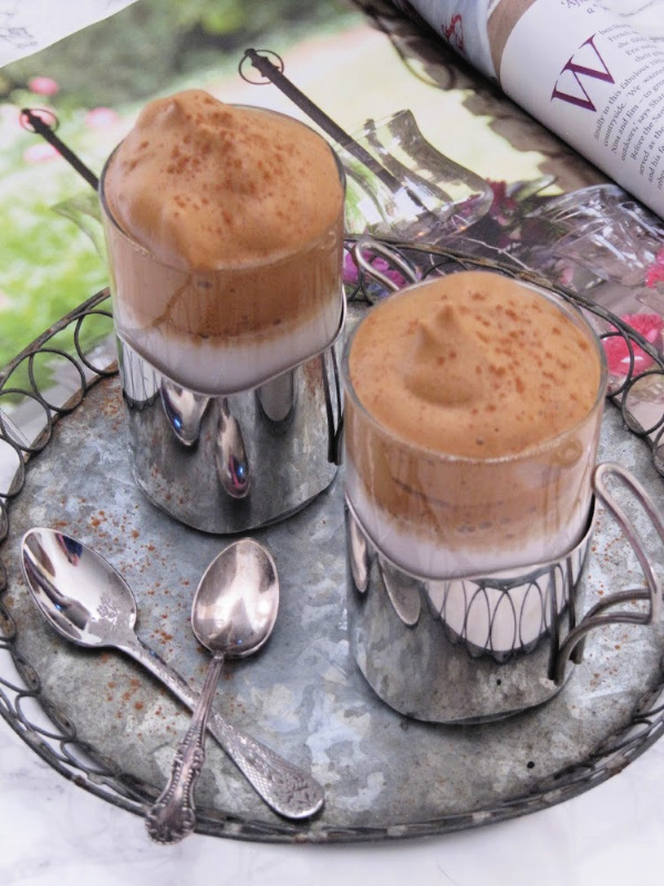 Vanilla Dalgona Whipped Coffee in silver cups on a zinc tray with a magazine