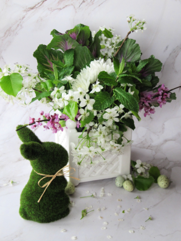 Flower arrangement with cherry blossoms and a moss covered bunny