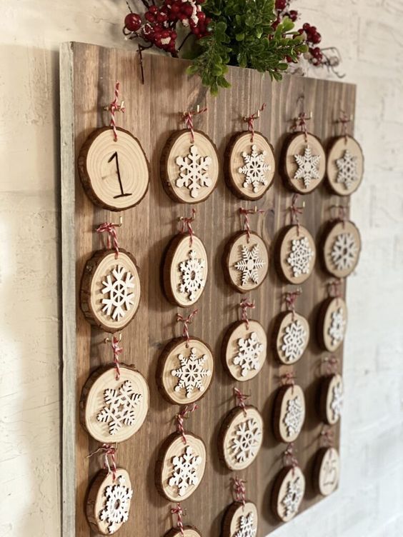Wood board with small round pieces of wood decorated with snowflakes and numbers advent calendar
