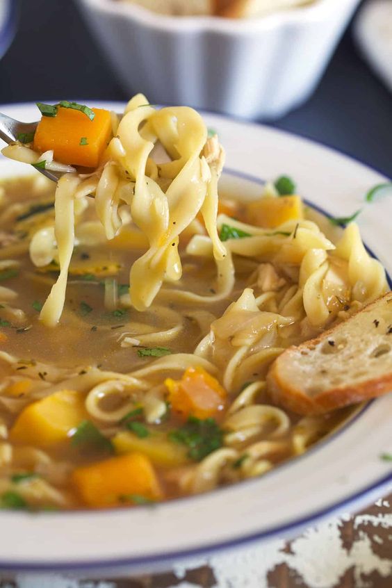 Turkey Noodles Soup in a white bowl with blue rim