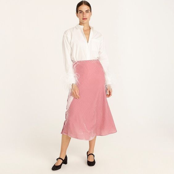 lady wearing a pink velvet skirt with white blouse
