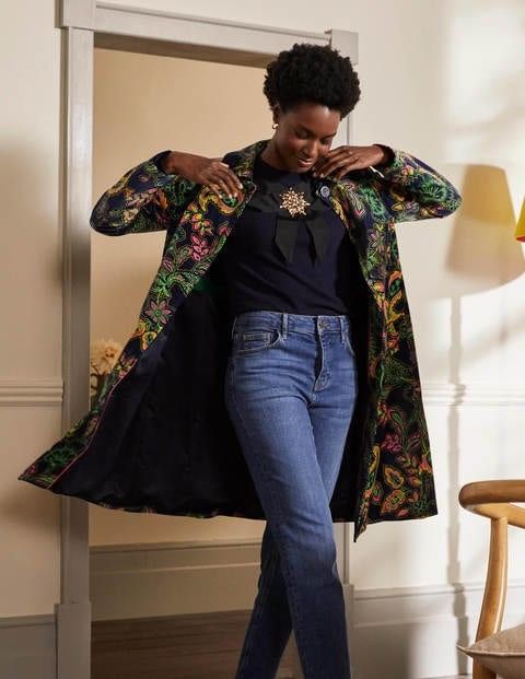 lady putting on a colorful velvet coat