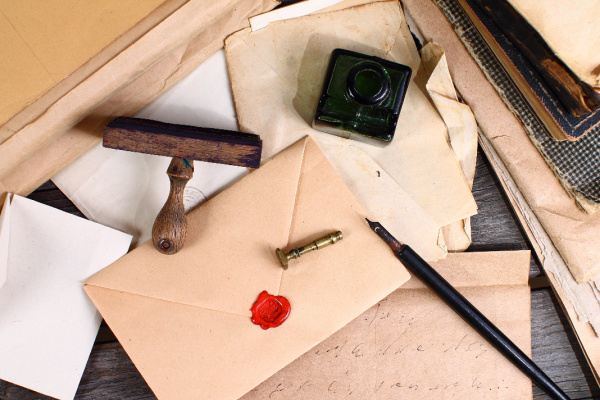 hand written letters and envelopes with a pen and jar of ink 