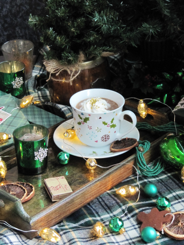 Christmas trees and hot chocolate with shades of green glass on a plaid tablecloth