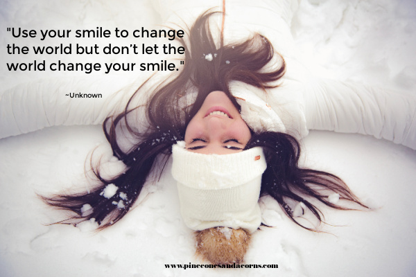 a girl laying in the snow smiling with the quote don't let the world change your smile