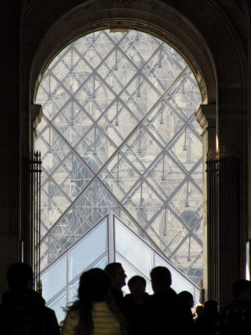 The glass pyramid of the Louvre through a portal