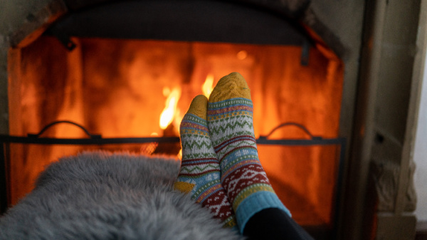 stocking feet on an ottoman in front of a roaring fire