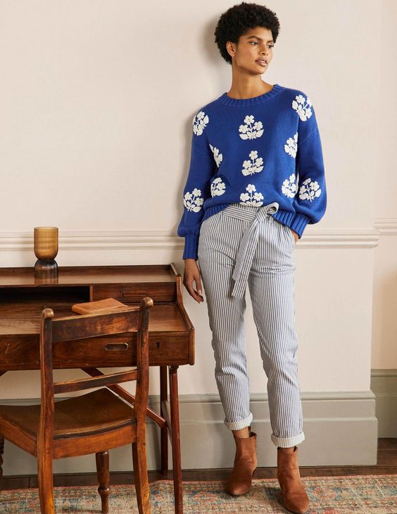 woman wearing a Blue sweater with white appliqués
