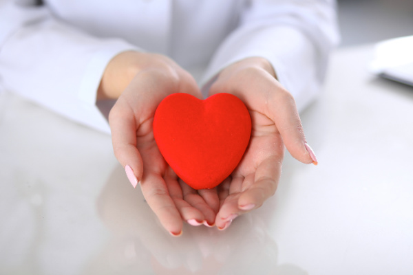 two hands holding a red heart