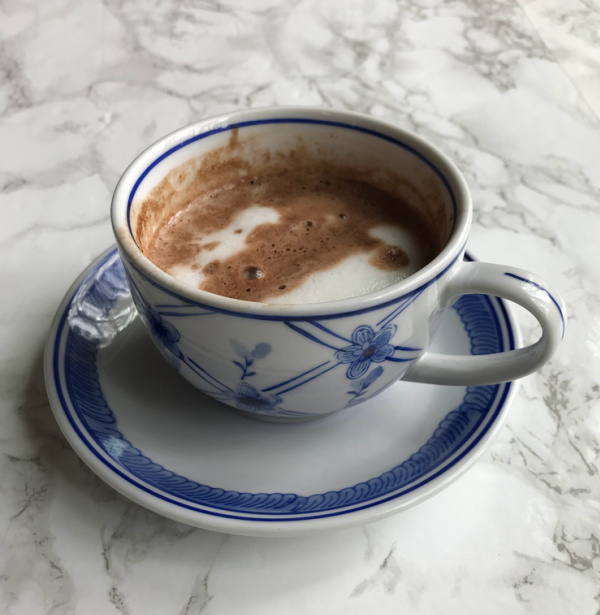 hot chocolate with foam in a blue and white cup