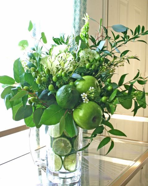 green flowers and fruit arrangement with apples and limes