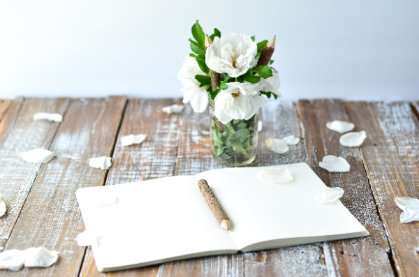 Morning journaling ritual for intentional living after 50 with vase of flowers and a journal and pen. 