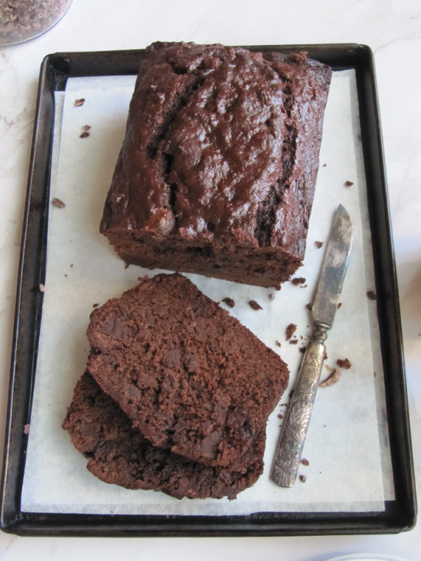 Sliced double chocolate banana bread on white parchment paper on a black pan