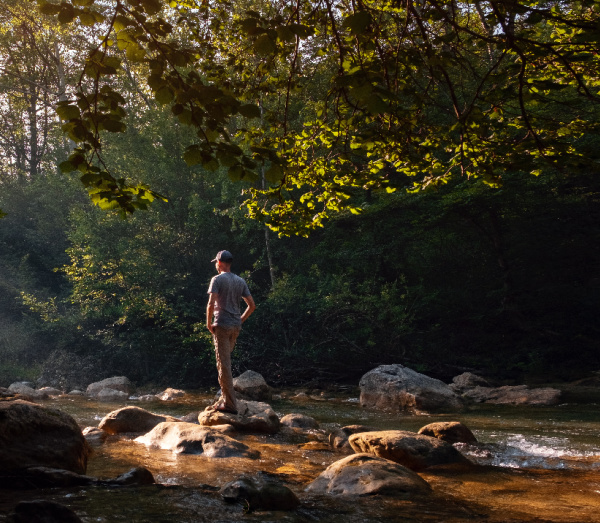 wednesday wellness man walking on the rocks in the river