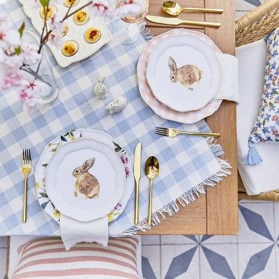 Blue and white gingham table cloth on wood table decorated for easter dinner