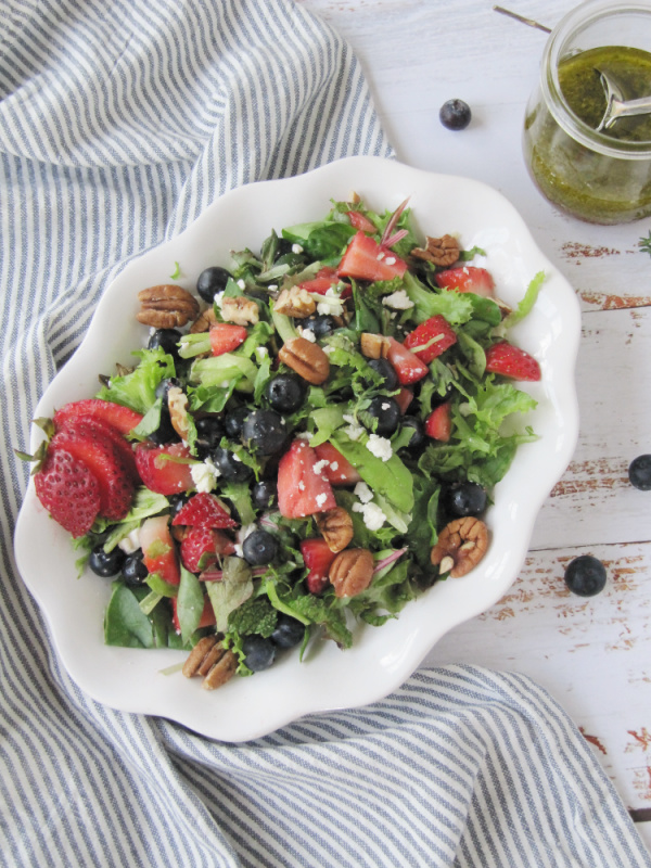 Strawberry and Fresh Herb Salad with Blueberries and Feta cheese on a white plate.
