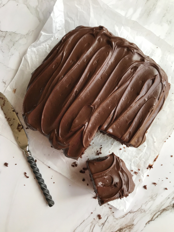 chocolate snack cake with a knife and a piece cut out