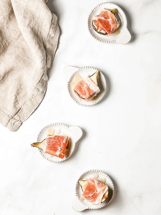 Procuitto Wrapped figs on 4 white plates
