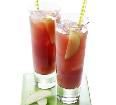 two tall glasses with pink liquid and apple slices and a straw