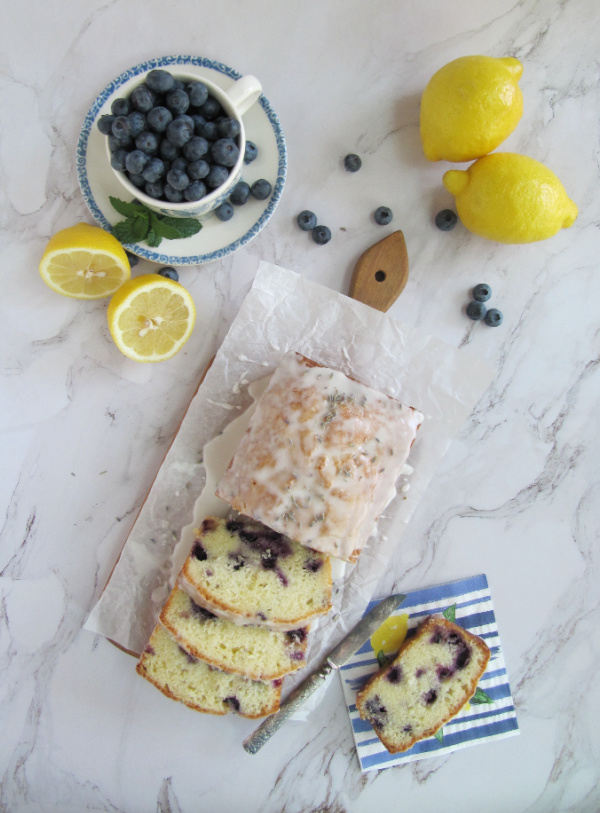 BLUEBERRY LEMON LAVENDER BREAD with lemons and a cup of blueberries sliced